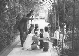 As crianças apreciam o jardim, guiadas pelas professoras